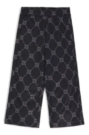 Kids' loose-fit tracksuit bottoms with stacked-logo print